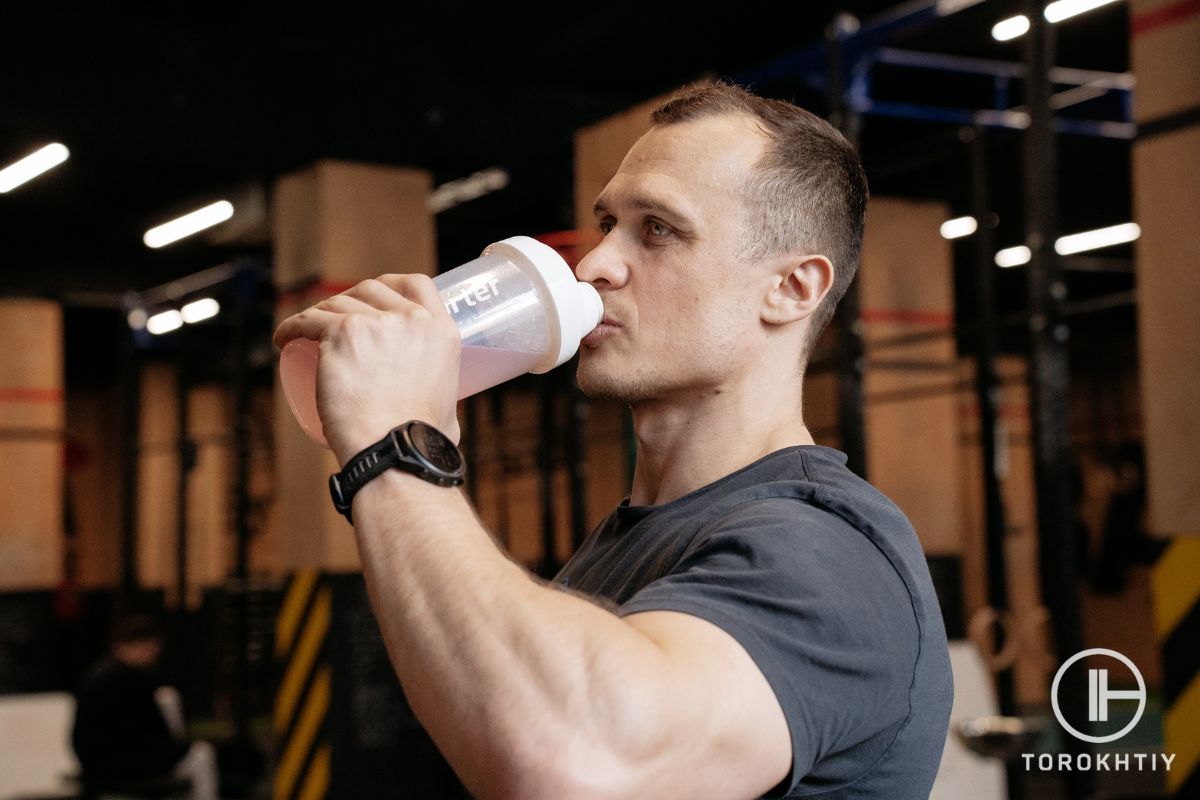 Athlete drinking a recovery supplement after training