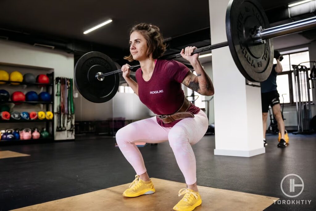 woman back squat in gym