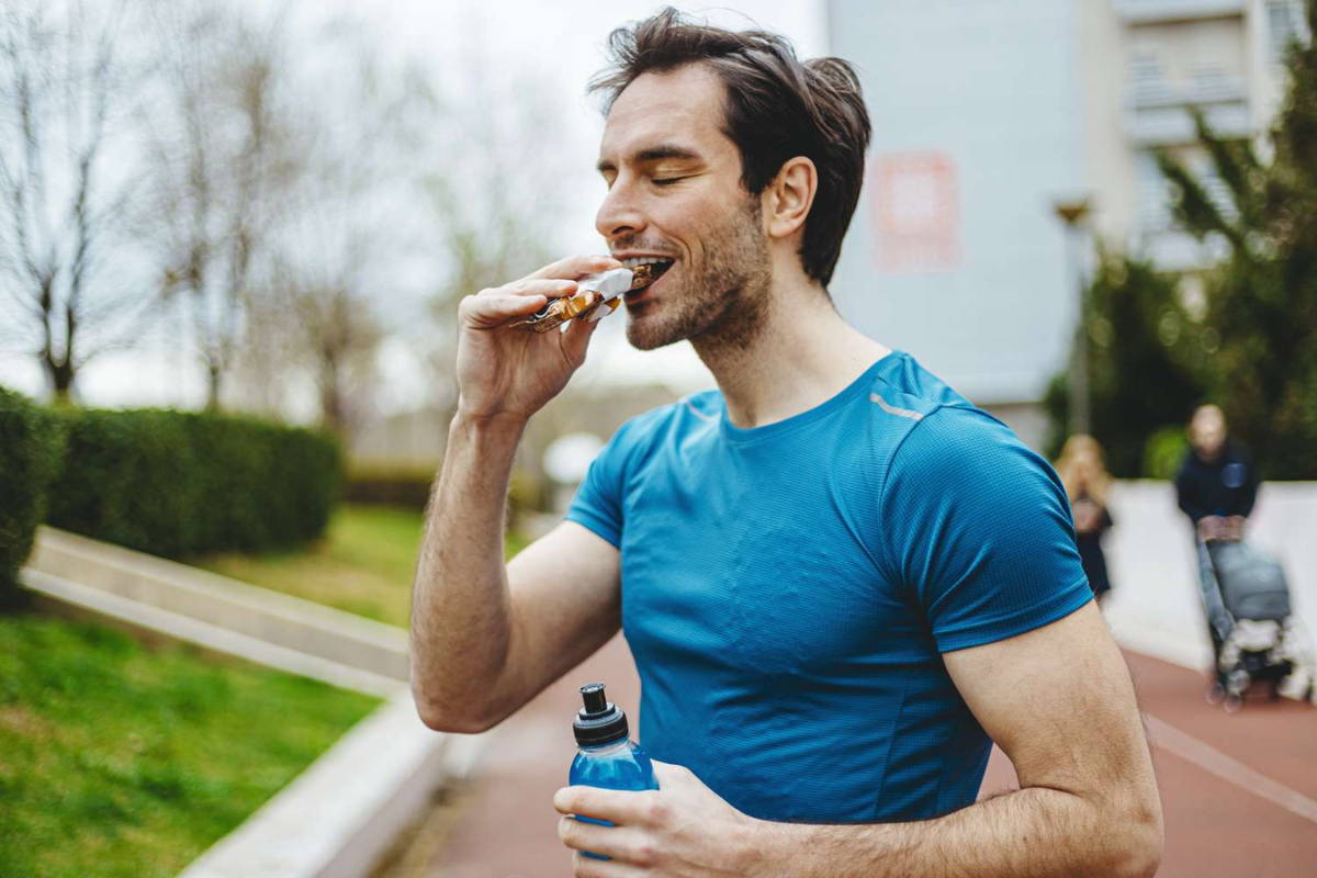 Man athlete drink shake and eat protein bar