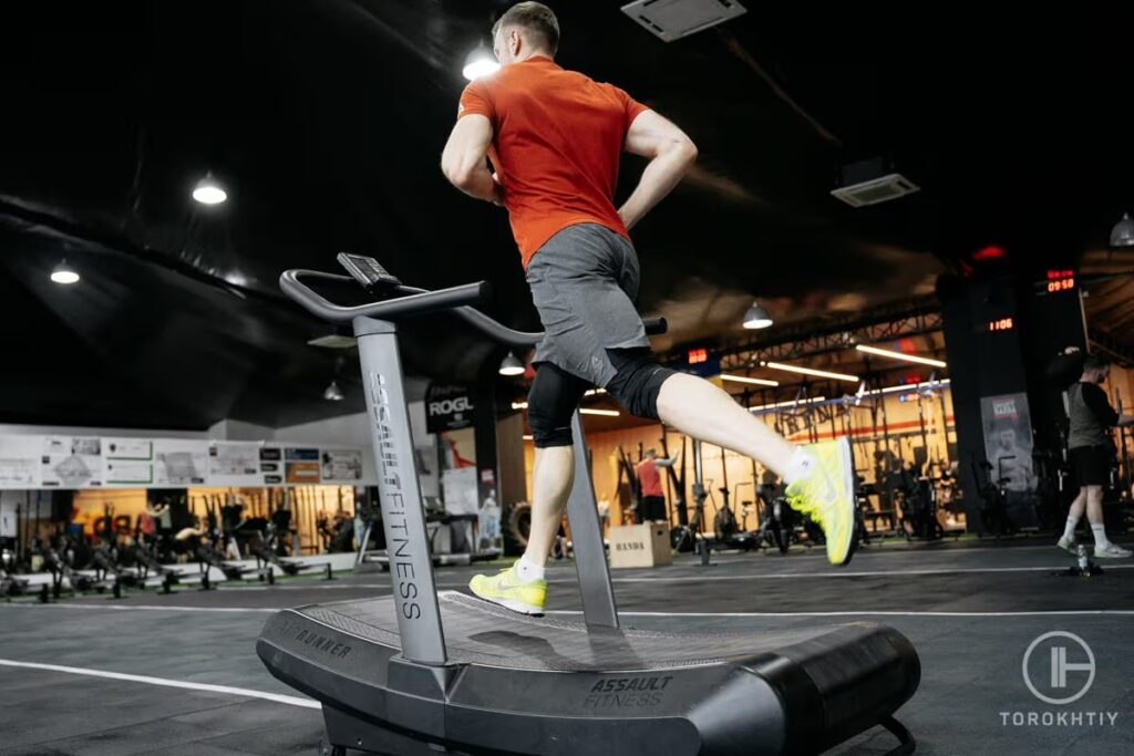 athlete in orange shirt running on treadmill