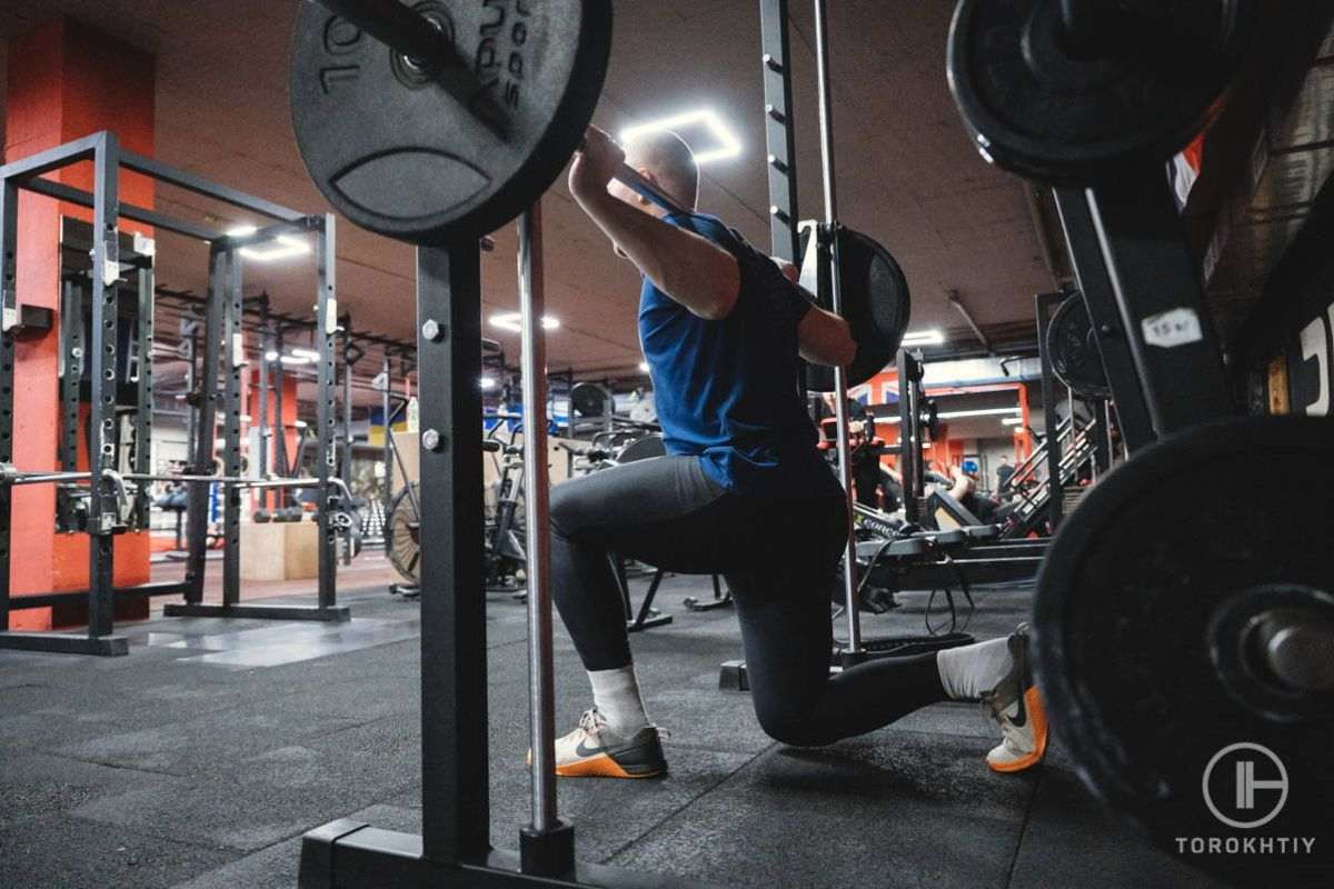 Athlete squatting using smith machine