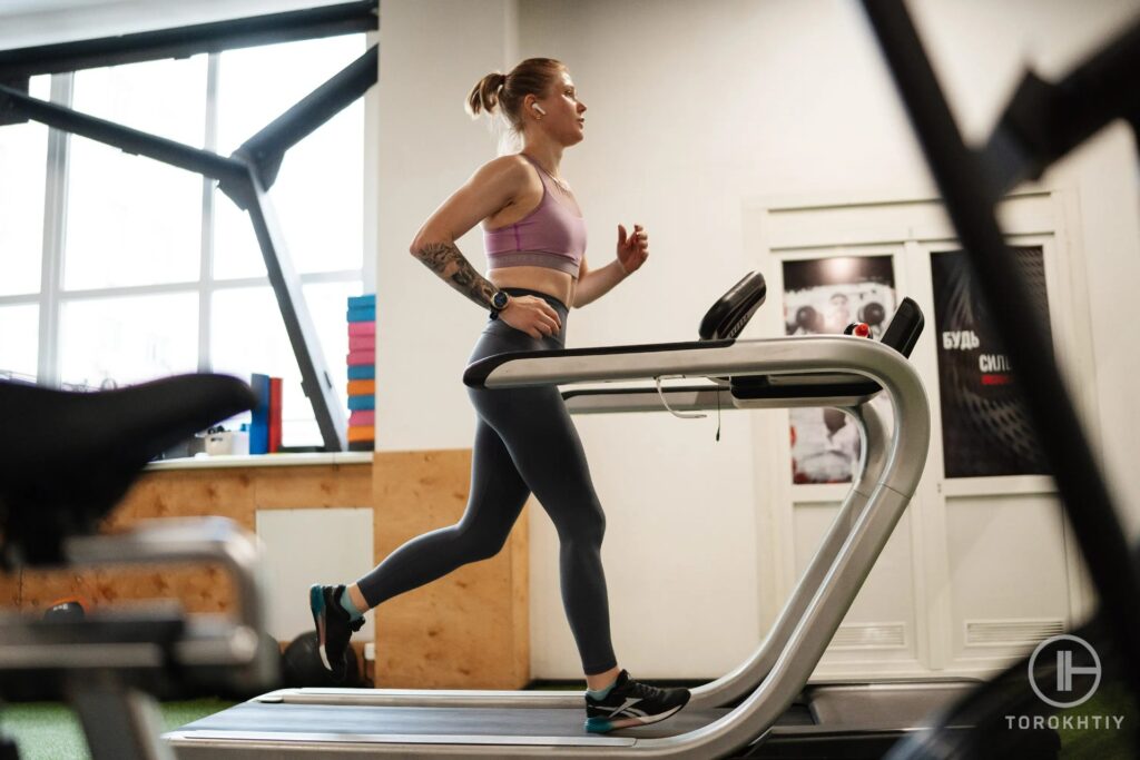 female athlete in pink running right on treadmill
