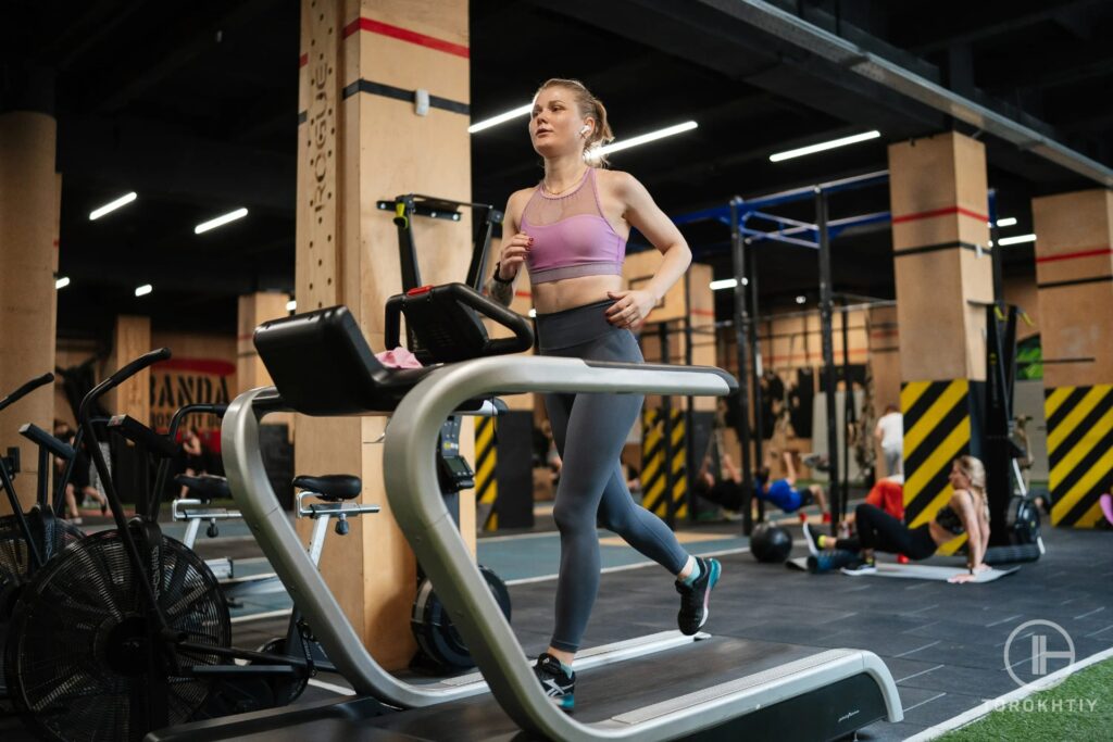 female athlete in pink top running on treadmill