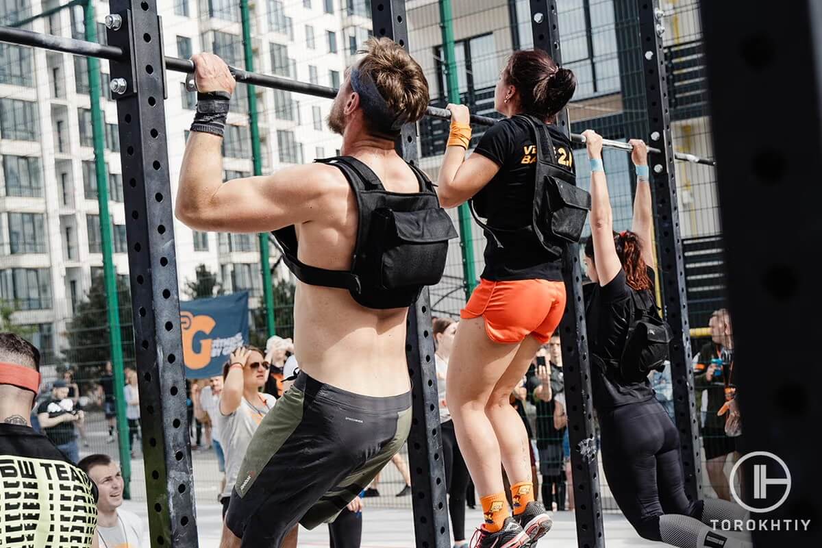 Athletes doing pull-ups with weighted vests