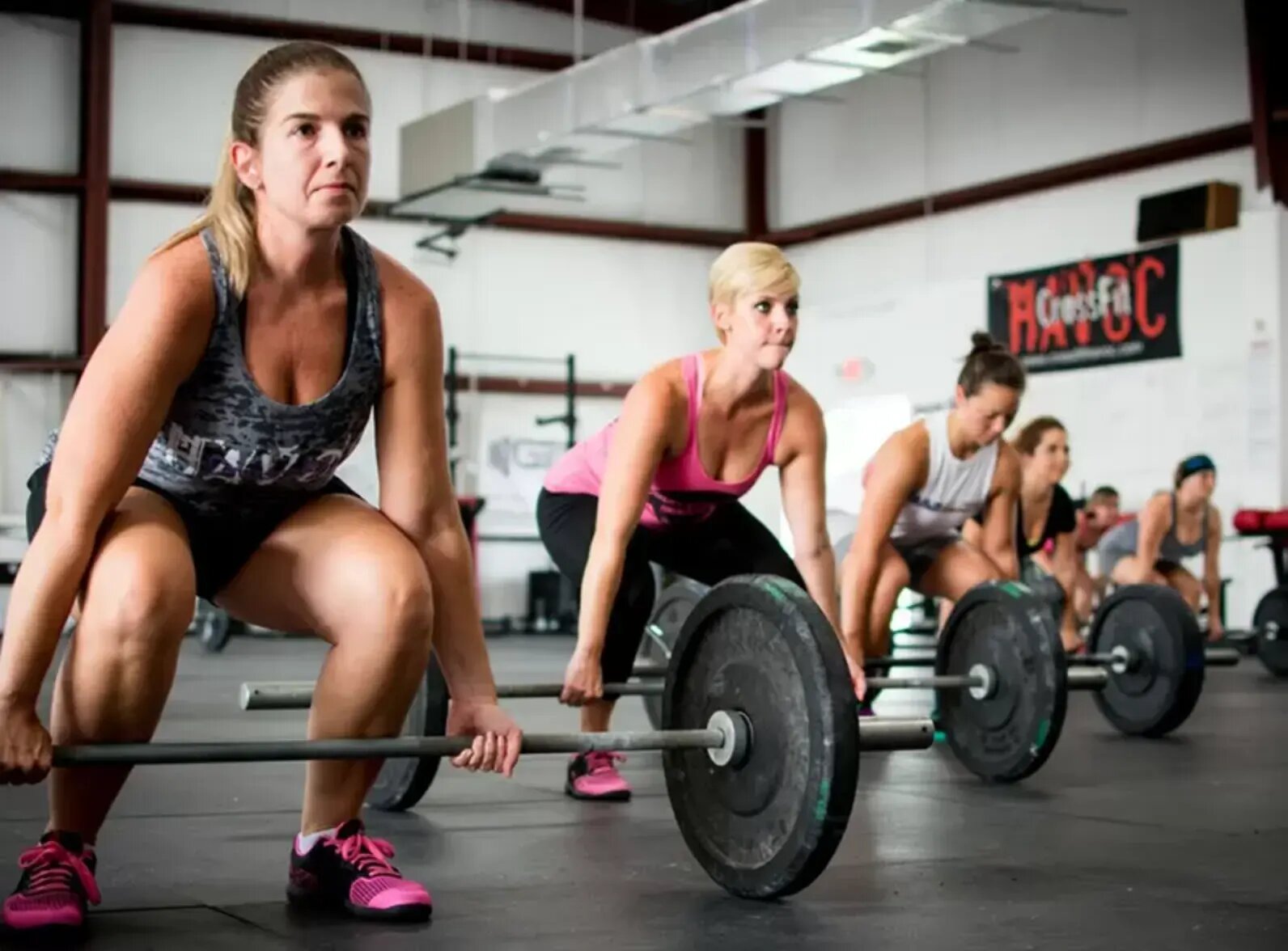 athlete women doing fitness exercise with barbells