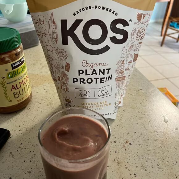 kos protein shake in glass and pack on table