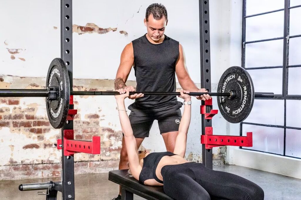 woman and man do exercise by squat rack