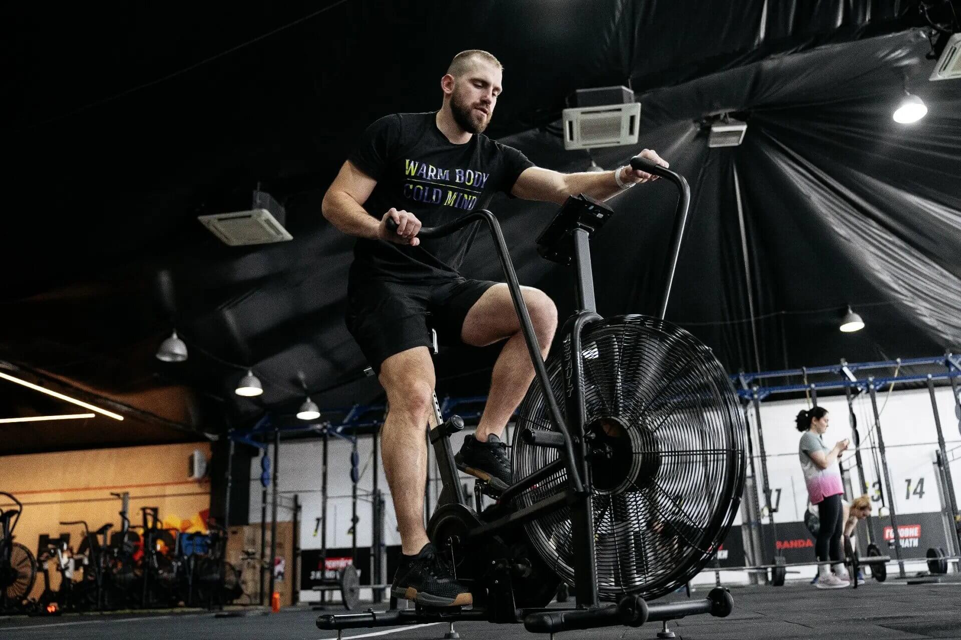 athlete exercising on echo bike in gym