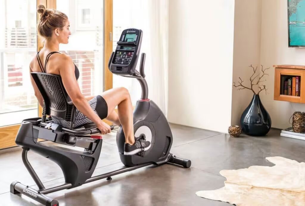 woman exercises on recumbent bike at home