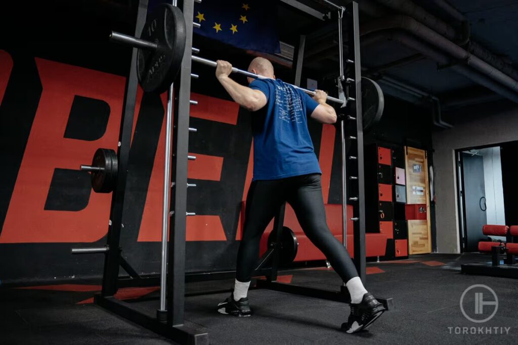 athlete exercises with squat rack