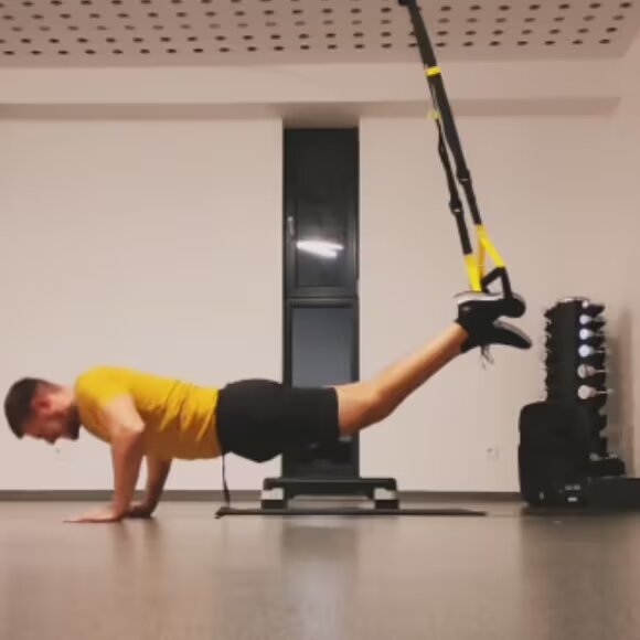 man workos out with suspension trainer