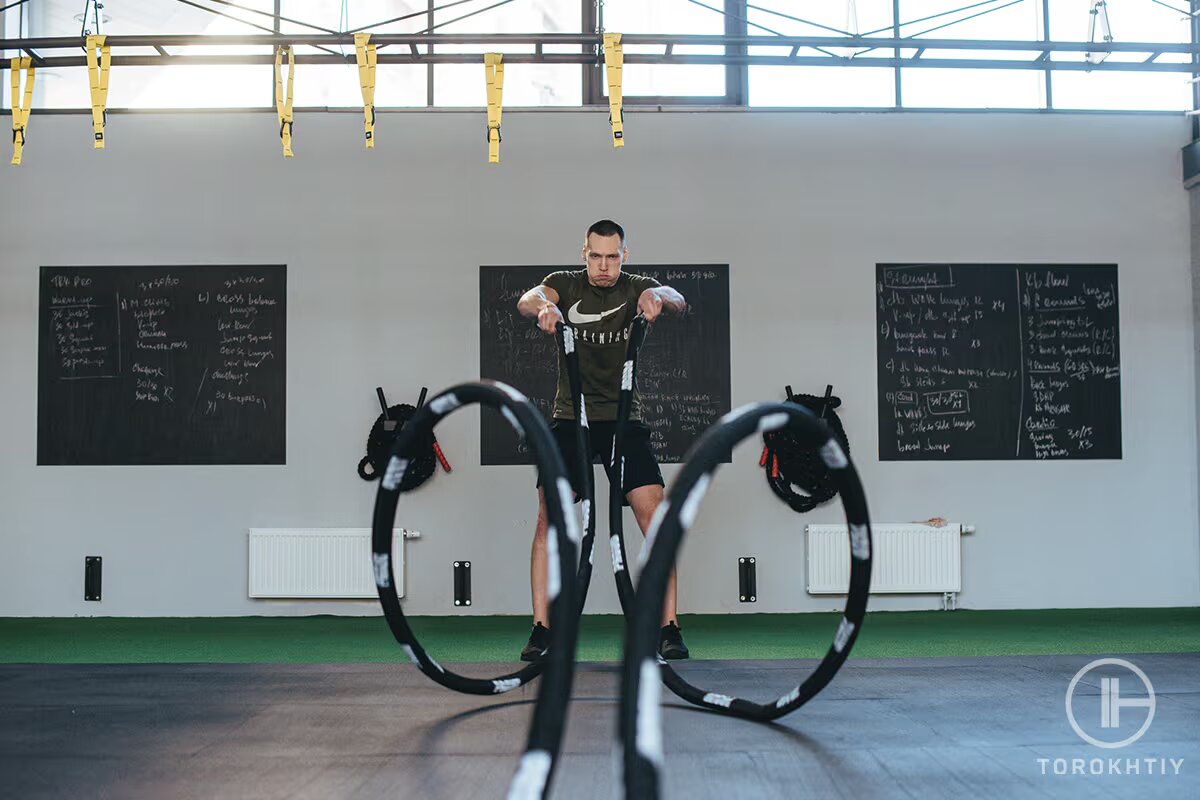 athlete man works out with rope
