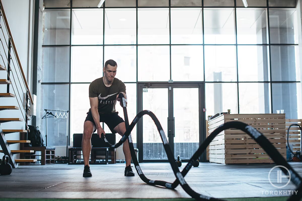 athlete trains with rope in gym