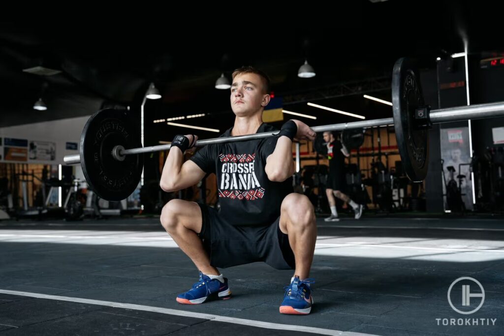 young athlete lifts barbell