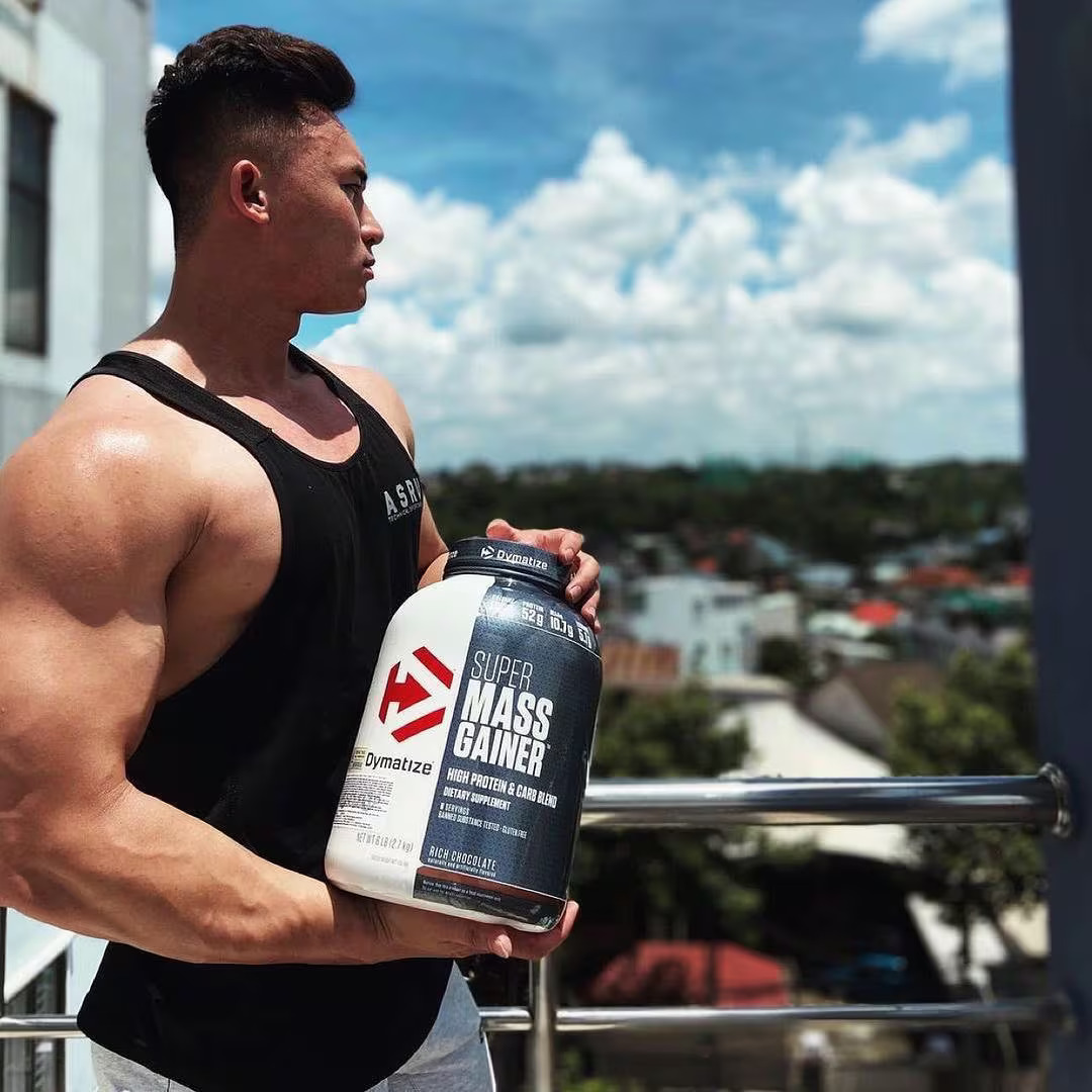 man holding Dymatize’s Super Mass Gainer supplement