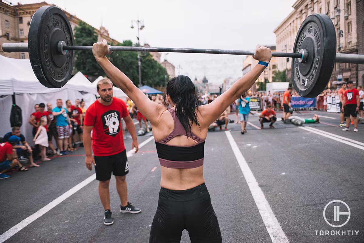 athlete woman lifting barbell on competition