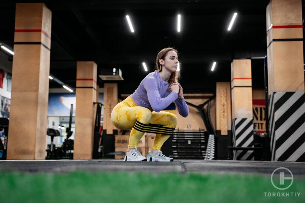 woman exercises with resistance band in gym