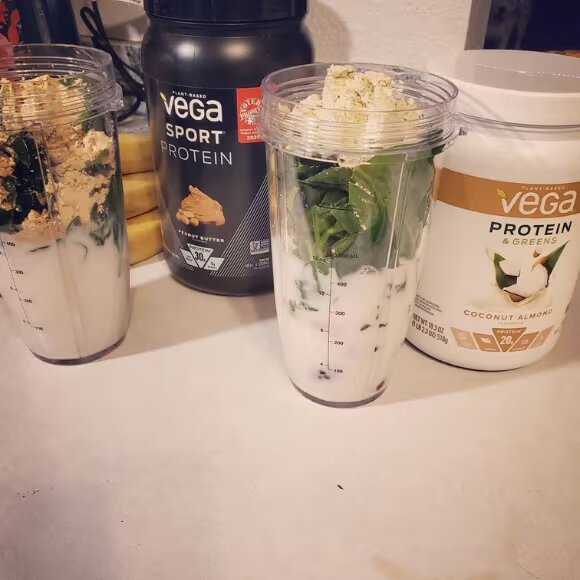 vega protein shake in glass and bottle on table