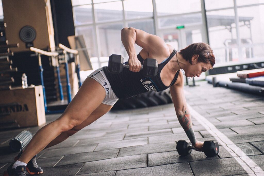 athlete woman doing exercise with dumbbells