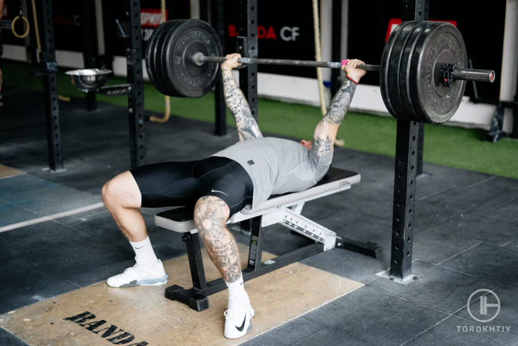 athlete doing workout on weight bench in gym