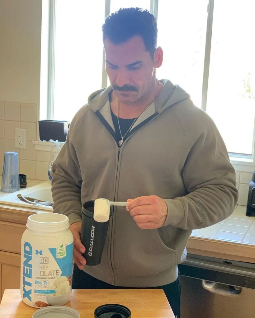 man making protein shake at home