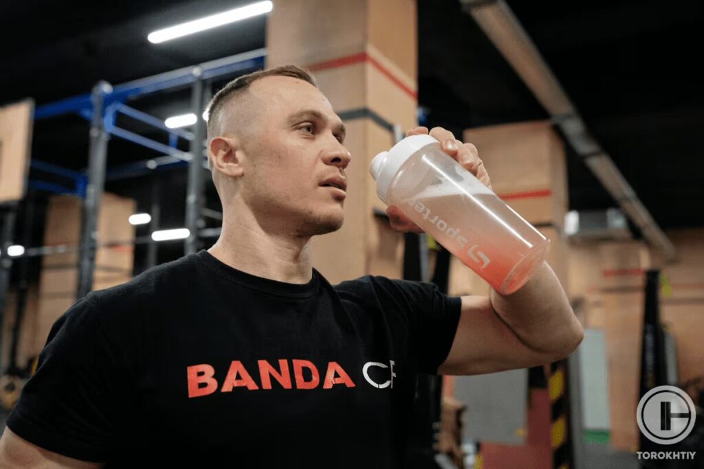 athlete takes protein supplement shake