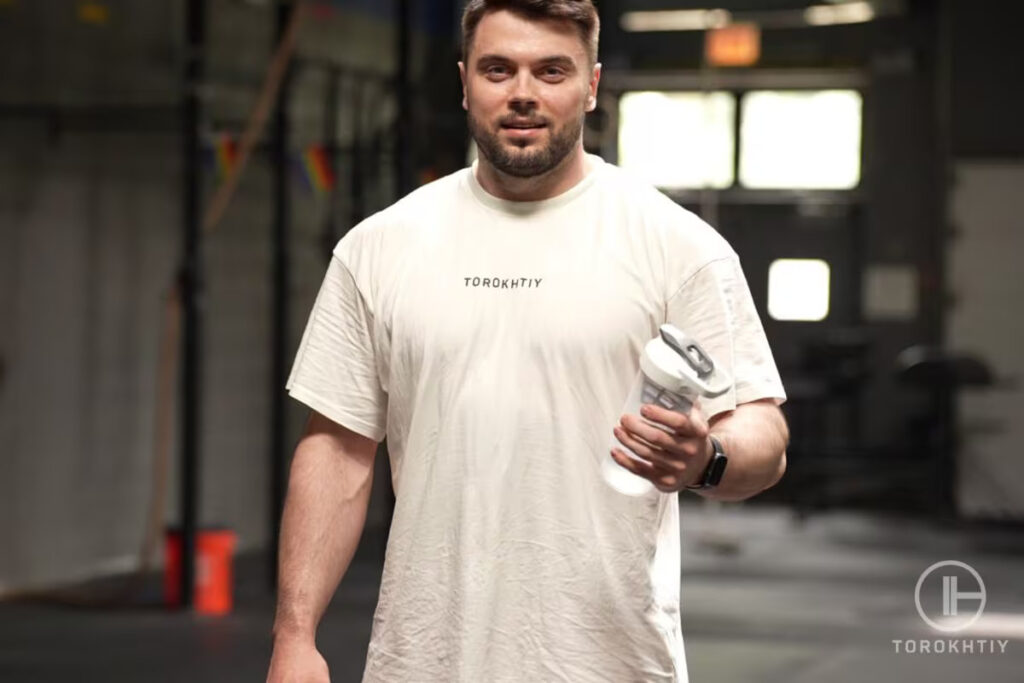 athlete holds protein shake bottle