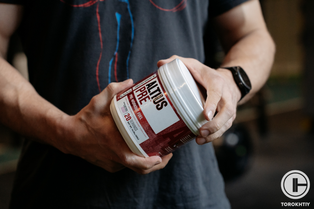 athlete holding jar of pre-workout