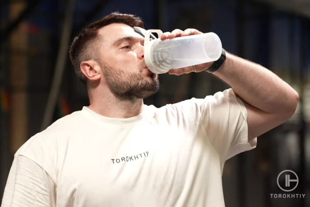 athlete is drinking creatine supplement shake