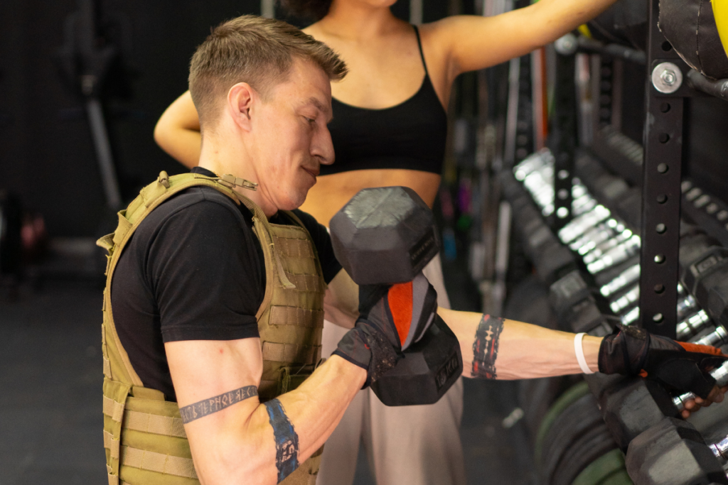 workout with dumbbells in a weighted vest