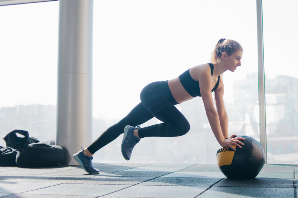 woman making mountain climber with medicine ball