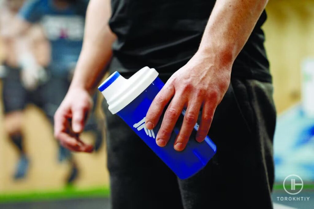 athlete holds supplement bottle