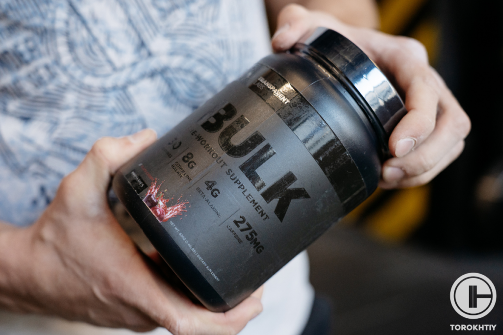 athlete holding jar of pre-workout