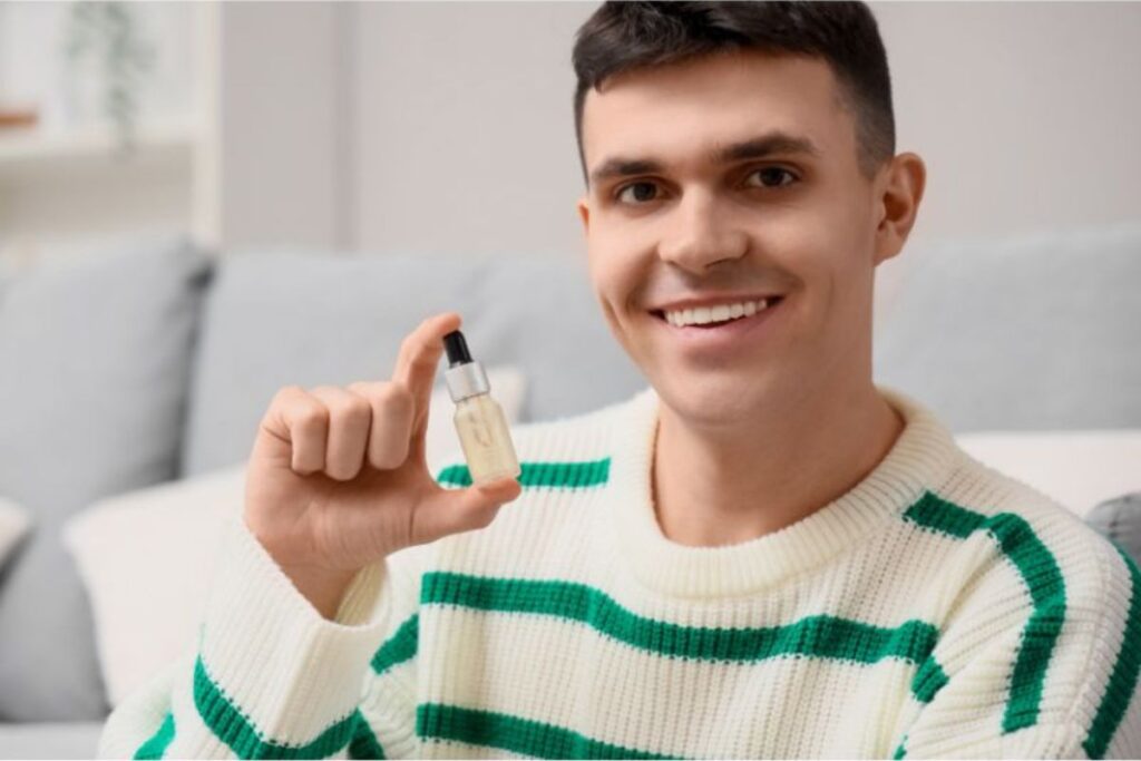 man holds a bottle of cbd