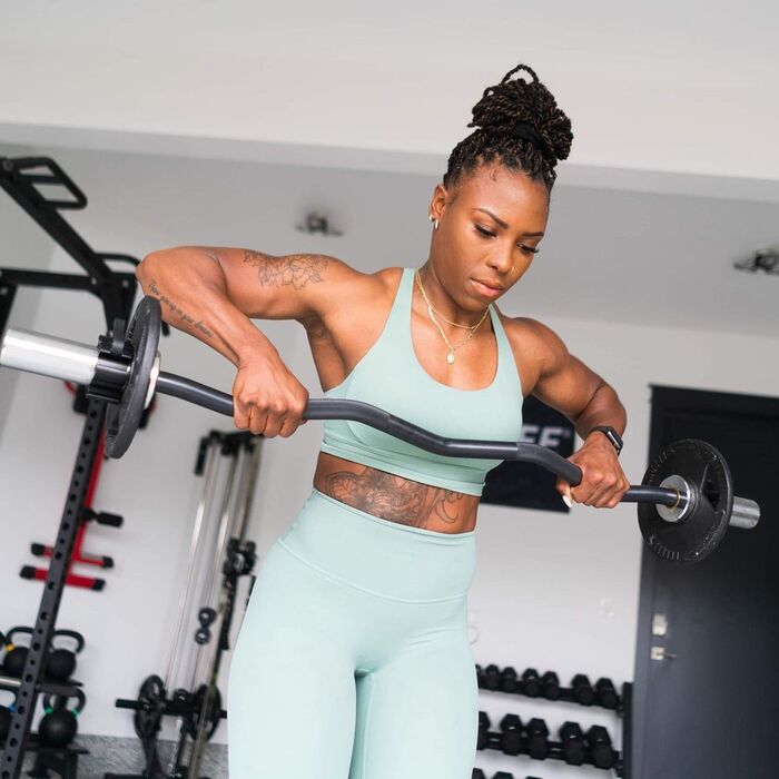 Woman doing a workout with a Synergee curl bar